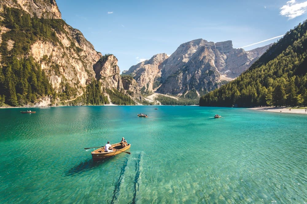 A clear blue lake bordered by forested mountains